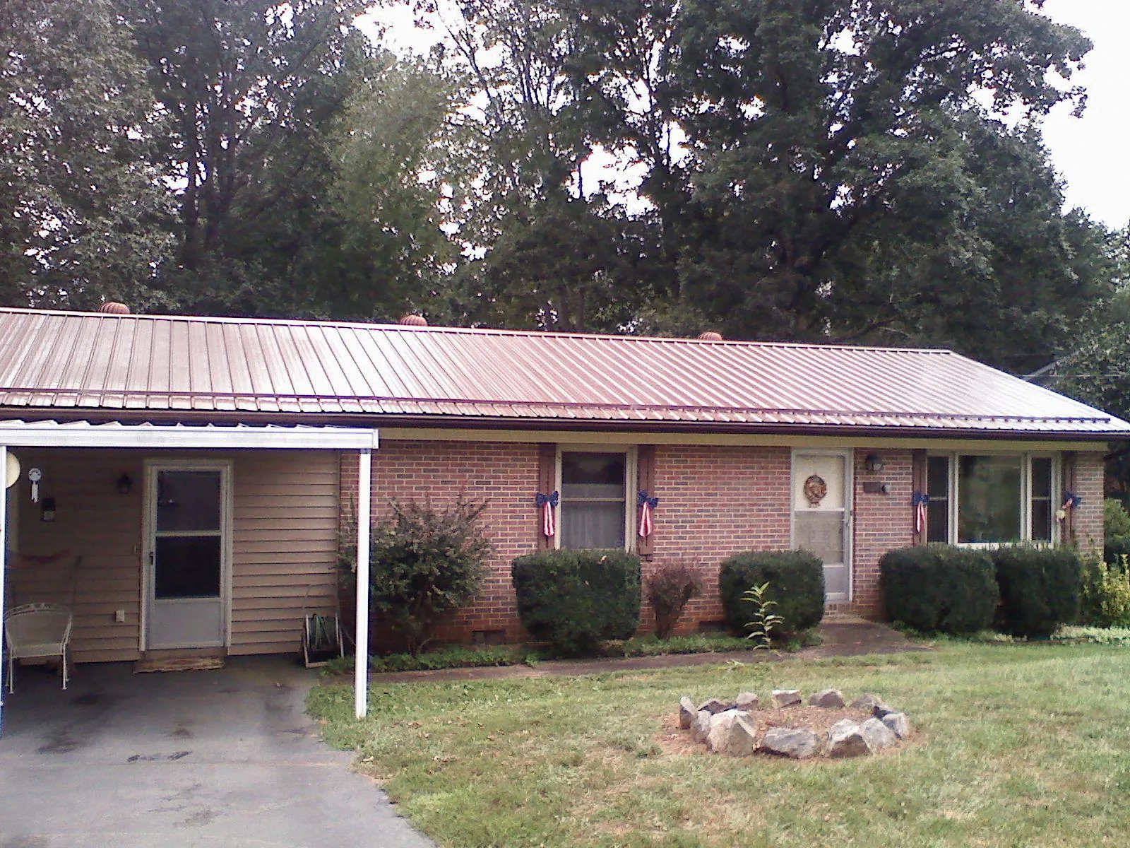 Bronze metal roof and carport on a brick ranch home — Roof Repair work by our crew in Palm