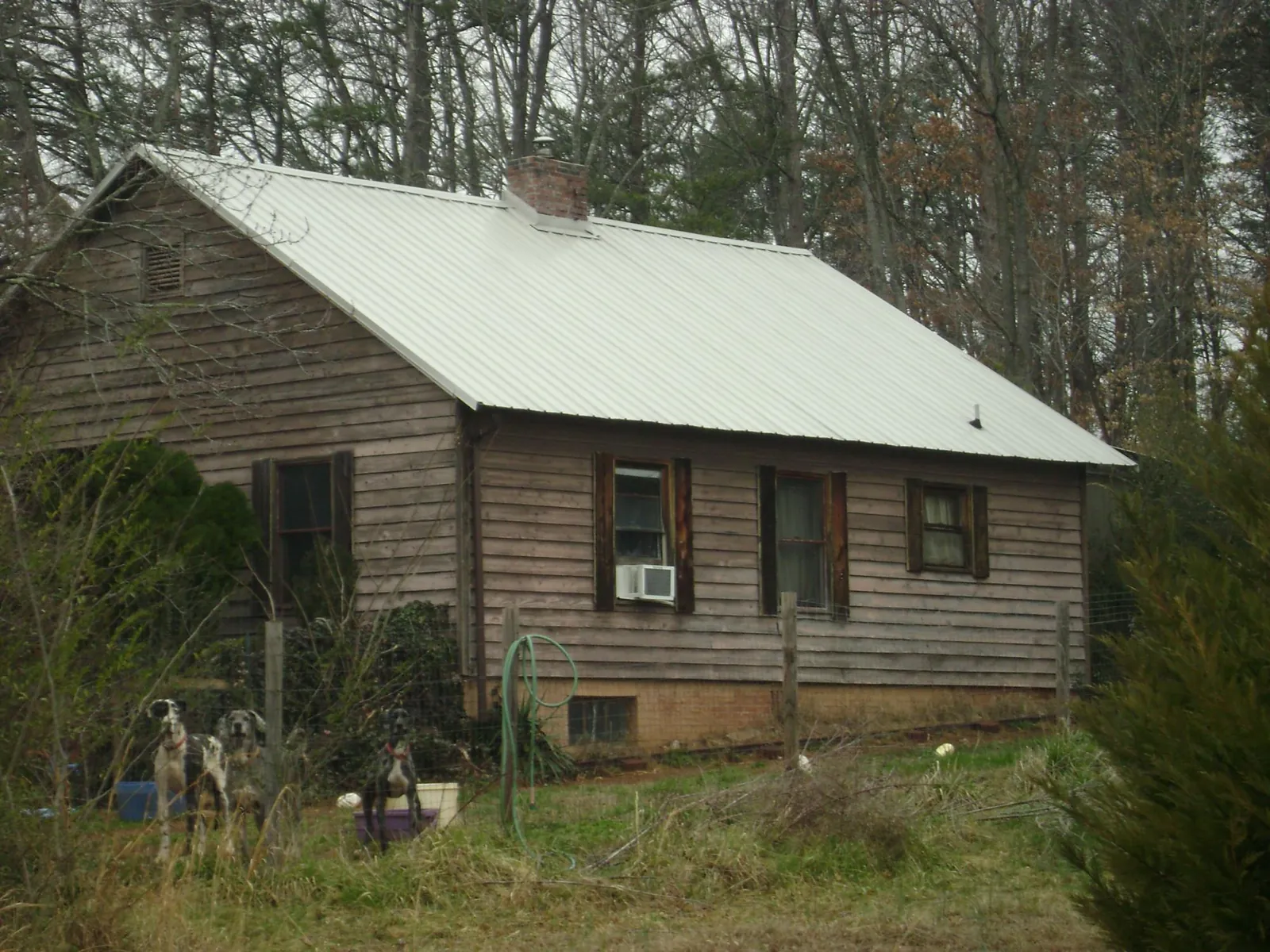 White metal roof on an old wood sided farmhouse, from a Metal Roof Installation job in Palm
